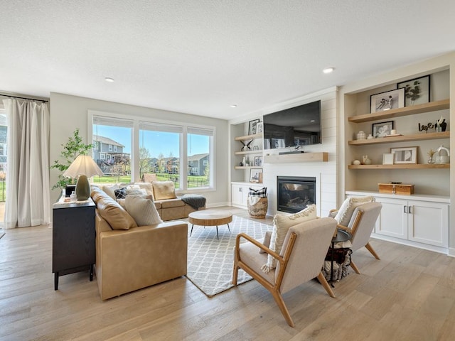 15441 110th Ave N, Dayton, MN 55369 - living room featuring light wood-style floors, a textured ceiling, a fireplace, built in features, and recessed lighting
