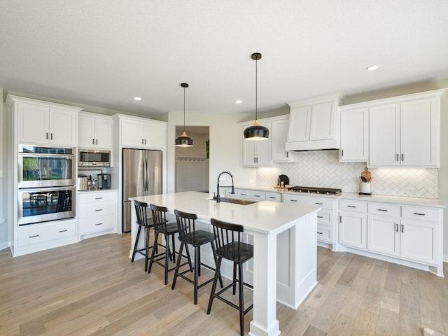 15441 110th Ave N, Dayton, MN 55369 - kitchen with appliances with stainless steel finishes, a sink, light wood-type flooring, a kitchen bar, and backsplash