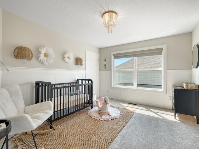 15441 110th Ave N, Dayton, MN 55369 - bedroom featuring a decorative wall, a wainscoted wall, carpet floors, and a nursery area