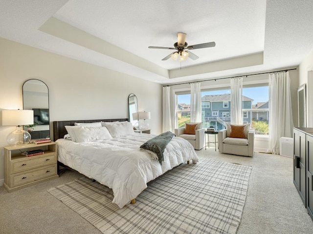 15441 110th Ave N, Dayton, MN 55369 - bedroom featuring a tray ceiling, light carpet, and ceiling fan