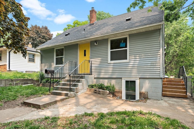 549 Annapolis St E, Saint Paul, MN 55118 - view of front of house featuring a chimney, a patio area, and roof with shingles