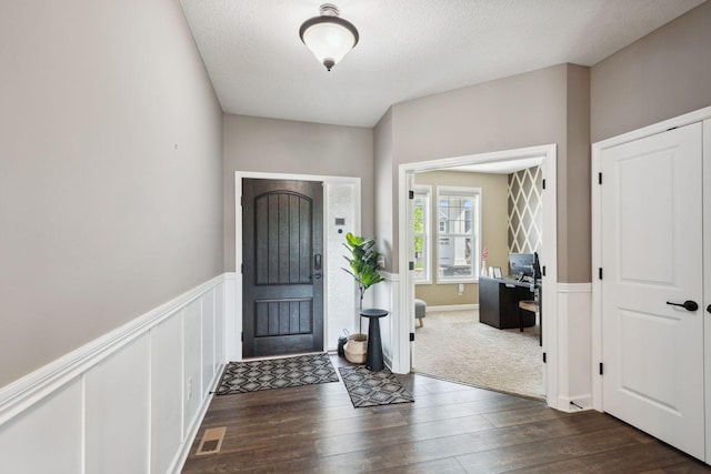 4847 Ashton Curv, Woodbury, MN 55129 - entryway with dark wood finished floors, a textured ceiling, and a wainscoted wall
