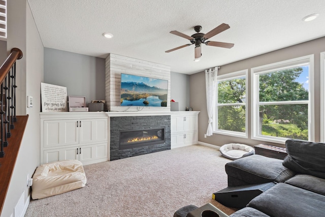 4847 Ashton Curv, Woodbury, MN 55129 - living room with carpet floors, a ceiling fan, a stone fireplace, baseboards, and a textured ceiling