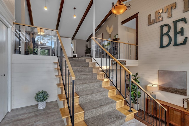 1276 13th Ave N, Saint Cloud, MN 56303 - stairway featuring beamed ceiling, wood finished floors, high vaulted ceiling, and wood walls
