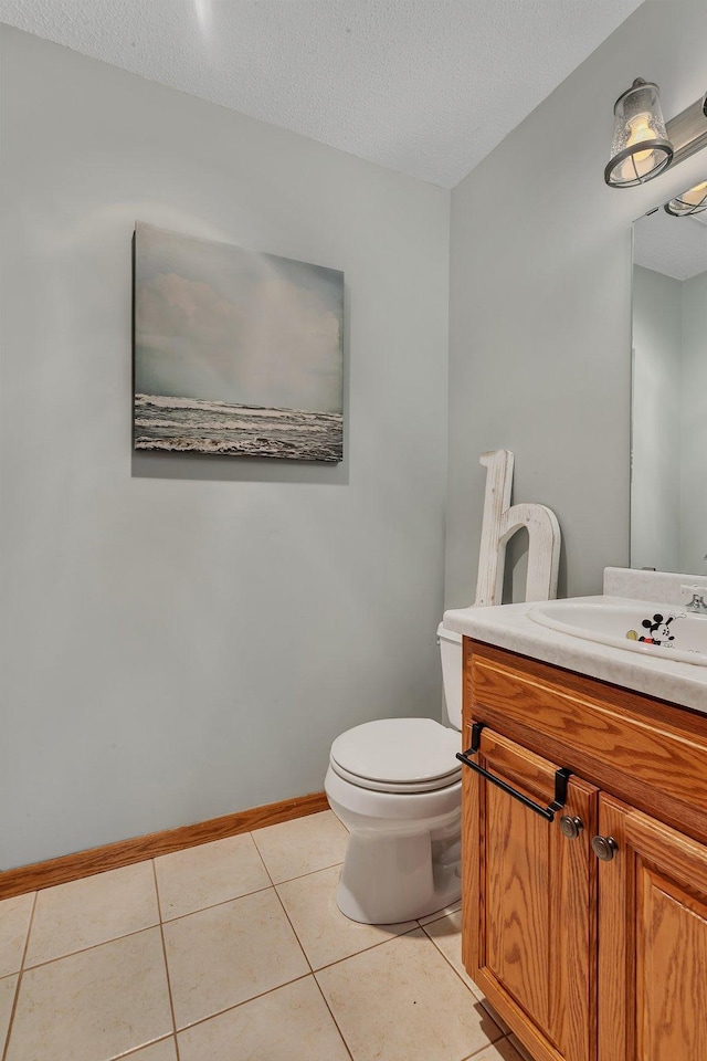 1276 13th Ave N, Saint Cloud, MN 56303 - half bath with vanity, toilet, tile patterned flooring, a textured ceiling, and baseboards