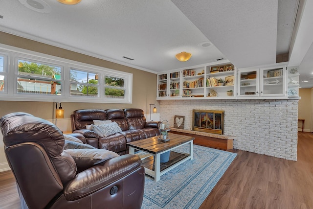 1276 13th Ave N, Saint Cloud, MN 56303 - living area with wood finished floors, a textured ceiling, a brick fireplace, and ornamental molding