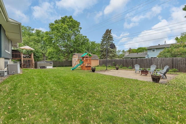 1276 13th Ave N, Saint Cloud, MN 56303 - view of yard with a playground, a patio area, an outdoor fire pit, a hot tub, and a storage shed