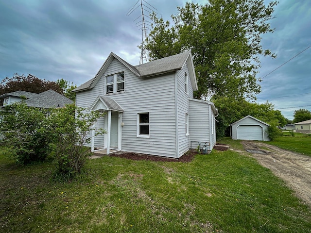 216 Main Ave S, New York Mills, MN 56567 - view of front of house featuring driveway, an outbuilding, a detached garage, a front yard, and a shingled roof