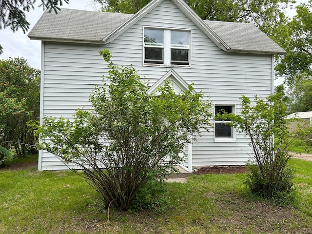 216 Main Ave S, New York Mills, MN 56567 - view of side of home with a lawn and roof with shingles