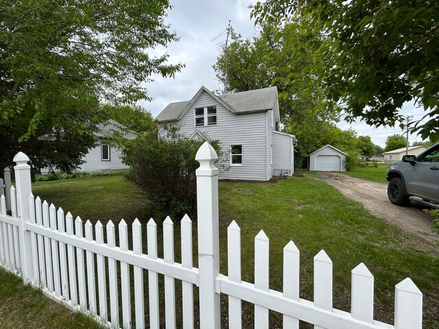 216 Main Ave S, New York Mills, MN 56567 - view of front facade with driveway, an outbuilding, and a detached garage
