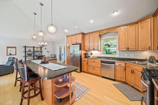 2445 Indian Way N, Saint Paul, MN 55109 - kitchen featuring appliances with stainless steel finishes, dark countertops, a breakfast bar, light wood-style flooring, and lofted ceiling