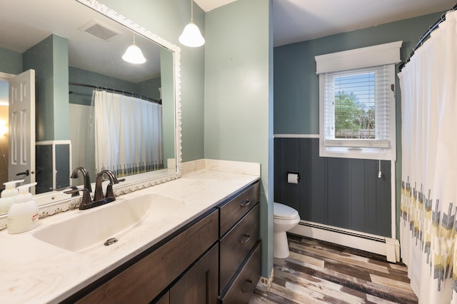 5851 Fairway Ln, Saint Cloud, MN 56303 - bathroom featuring a baseboard radiator, wood finished floors, vanity, and a wainscoted wall