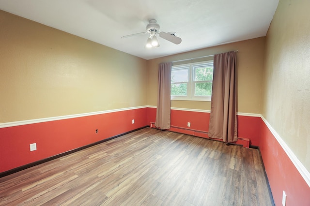 5851 Fairway Ln, Saint Cloud, MN 56303 - spare room with wood finished floors, ceiling fan, and a baseboard heating unit