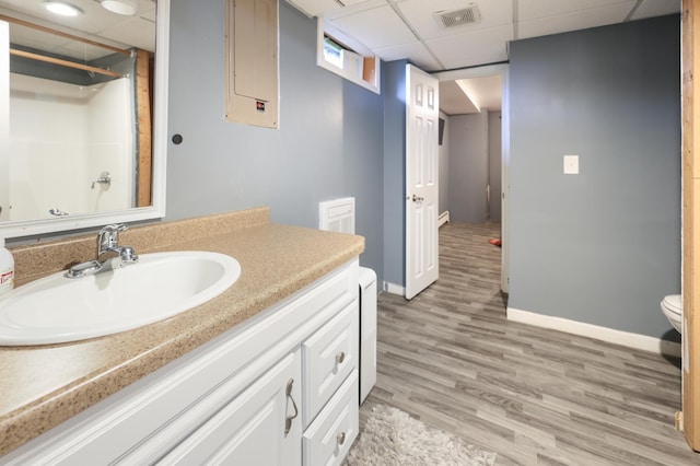5851 Fairway Ln, Saint Cloud, MN 56303 - bathroom with a paneled ceiling, vanity, wood finished floors, and a shower
