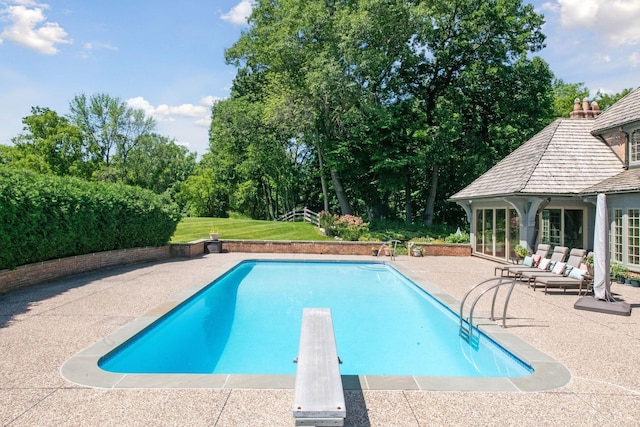 1150 Wyndmere Rd, Orono, MN 55391 - outdoor pool featuring a diving board, a patio, and view of wooded area