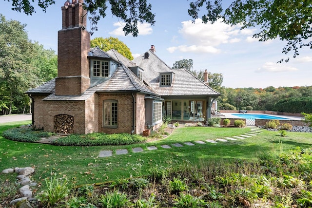 1150 Wyndmere Rd, Orono, MN 55391 - rear view of property with a chimney, brick siding, a yard, and an outdoor pool