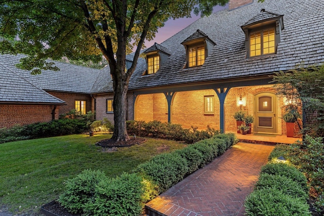 1150 Wyndmere Rd, Orono, MN 55391 - view of front facade featuring brick siding, a chimney, a lawn, and a porch