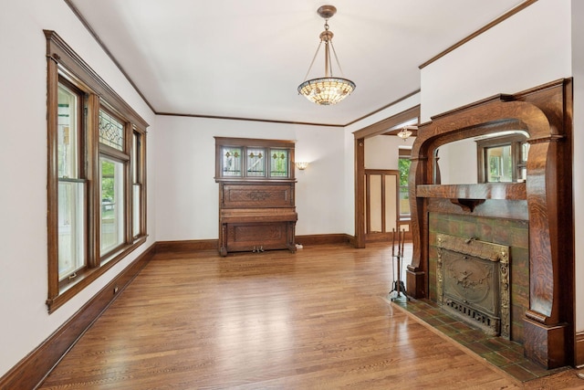 3252 Aldrich Ave S, Minneapolis, MN 55408 - unfurnished living room featuring baseboards, a chandelier, wood finished floors, plenty of natural light, and crown molding