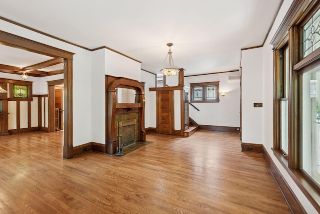 3252 Aldrich Ave S, Minneapolis, MN 55408 - empty room featuring wood finished floors, a fireplace with flush hearth, ornamental molding, baseboards, and a chandelier