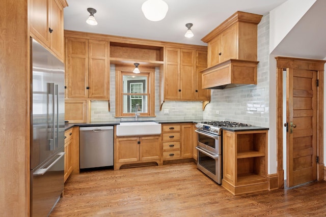 3252 Aldrich Ave S, Minneapolis, MN 55408 - kitchen featuring high quality appliances, open shelves, a sink, dark countertops, and light wood-style floors