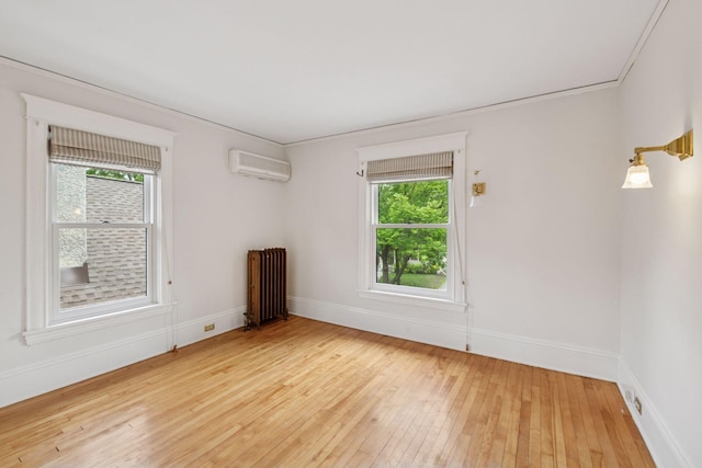 3252 Aldrich Ave S, Minneapolis, MN 55408 - empty room featuring radiator heating unit, a wall unit AC, plenty of natural light, and light wood finished floors