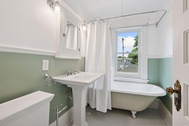 3252 Aldrich Ave S, Minneapolis, MN 55408 - full bathroom featuring a soaking tub, toilet, baseboards, and tile patterned floors