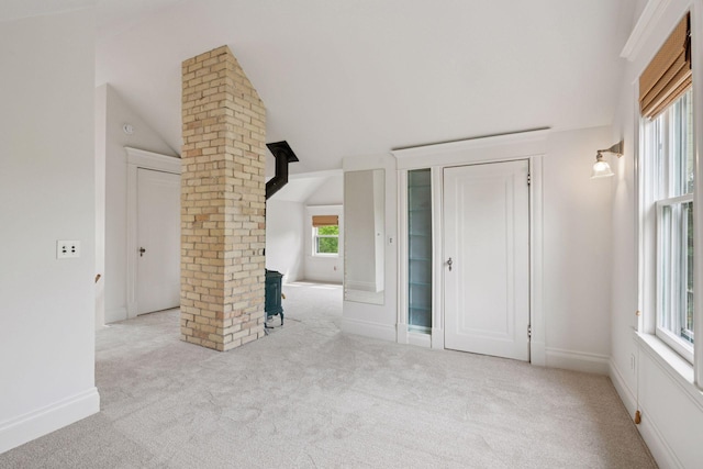 3252 Aldrich Ave S, Minneapolis, MN 55408 - unfurnished living room with lofted ceiling, carpet floors, decorative columns, and baseboards