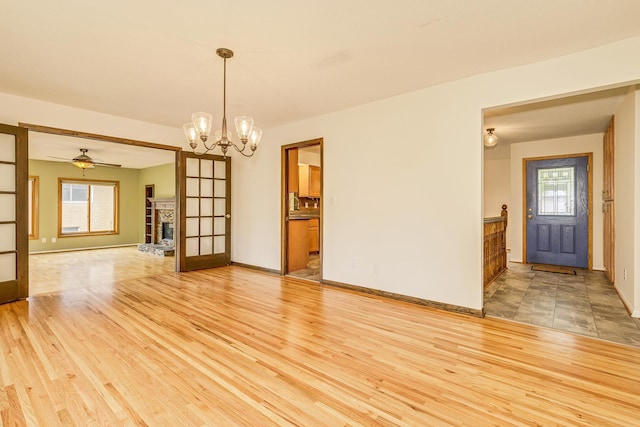 947 Dawn Ave, Shoreview, MN 55126 - empty room with a chandelier, plenty of natural light, light wood-style floors, and a stone fireplace