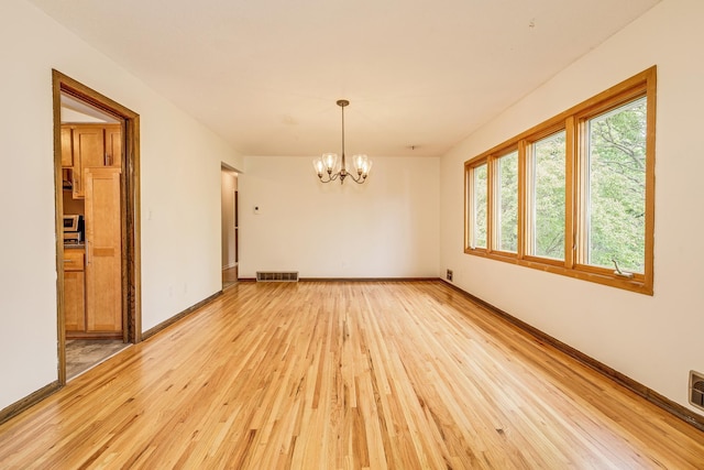 947 Dawn Ave, Shoreview, MN 55126 - empty room featuring light wood finished floors, a chandelier, and baseboards