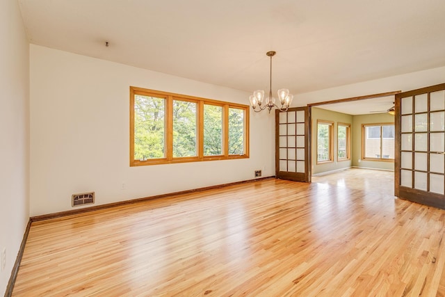 947 Dawn Ave, Shoreview, MN 55126 - empty room featuring light wood-style flooring, a chandelier, and baseboards