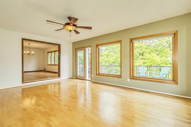 947 Dawn Ave, Shoreview, MN 55126 - empty room featuring a chandelier, a ceiling fan, light wood-style flooring, and baseboards