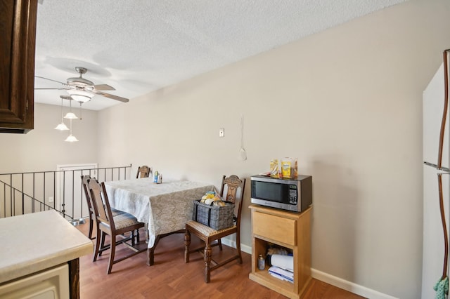 383 Elan Ct, Woodbury, MN 55125 - dining room with ceiling fan, light wood-style floors, a textured ceiling, and baseboards