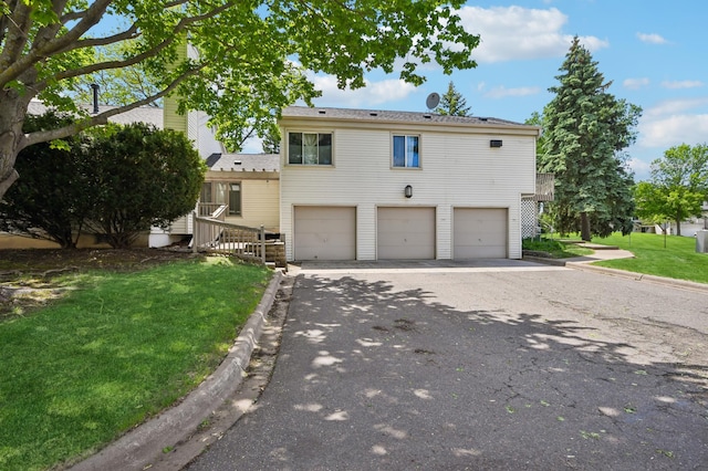 383 Elan Ct, Woodbury, MN 55125 - view of front of house featuring a garage, a front lawn, and asphalt driveway