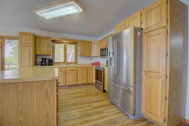 34347 Northview Rd, Everts Twp, MN 56515 - kitchen with stainless steel appliances, light brown cabinetry, and healthy amount of natural light
