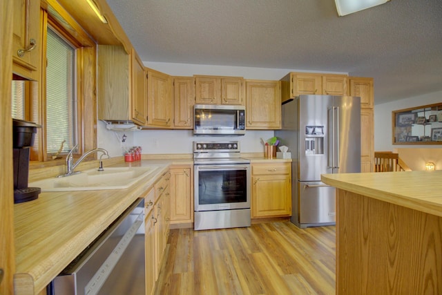 34347 Northview Rd, Everts Twp, MN 56515 - kitchen featuring appliances with stainless steel finishes, a sink, light countertops, a textured ceiling, and light wood-type flooring
