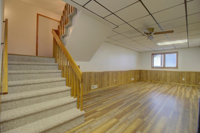 34347 Northview Rd, Everts Twp, MN 56515 - basement with wood finished floors, wainscoting, stairway, a ceiling fan, and a paneled ceiling