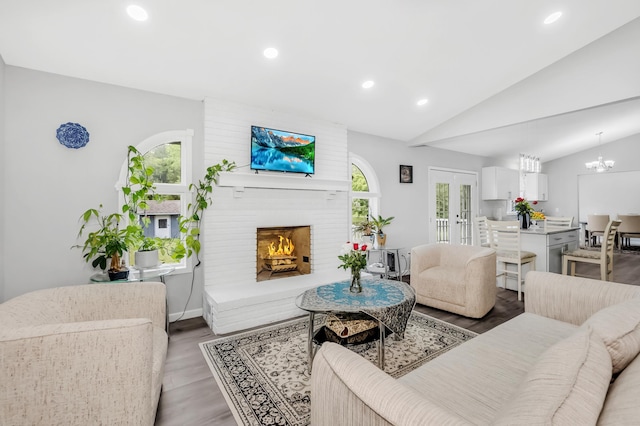 15710 Fox St NW, Andover, MN 55304 - living area with healthy amount of natural light, lofted ceiling, recessed lighting, a brick fireplace, and wood finished floors
