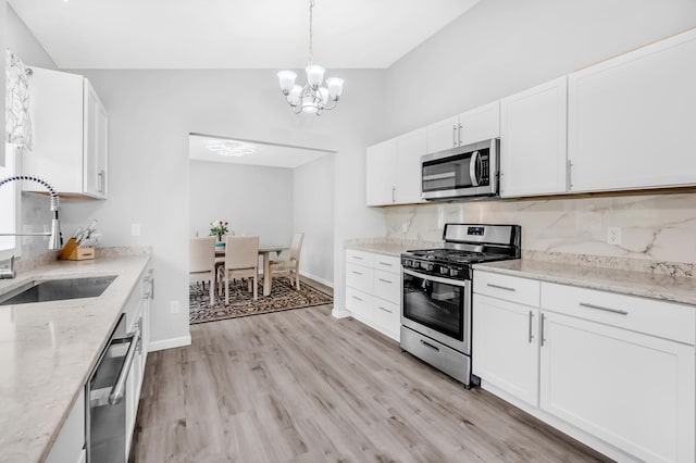 15710 Fox St NW, Andover, MN 55304 - kitchen with appliances with stainless steel finishes, a sink, a chandelier, backsplash, and white cabinetry