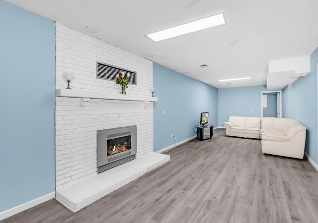 15710 Fox St NW, Andover, MN 55304 - unfurnished living room with a brick fireplace, wood finished floors, and baseboards