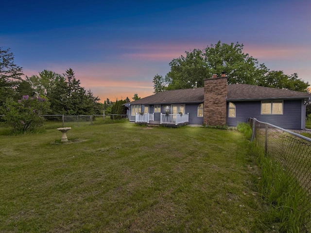 15710 Fox St NW, Andover, MN 55304 - back of house at dusk with a wooden deck, a chimney, and roof with shingles