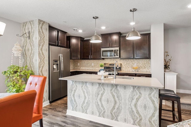 8061 Abercrombie Ln, Woodbury, MN 55129 - kitchen featuring appliances with stainless steel finishes, a sink, dark brown cabinets, light countertops, and a textured ceiling