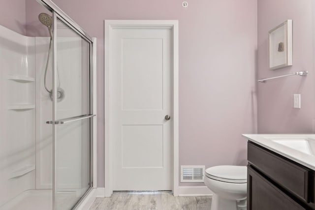 8061 Abercrombie Ln, Woodbury, MN 55129 - bathroom featuring a shower stall, vanity, wood finished floors, and toilet