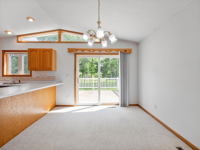 701 Janes Circle Dr SW, Alexandria, MN 56308 - kitchen featuring a chandelier, lofted ceiling, a sink, light carpet, and baseboards