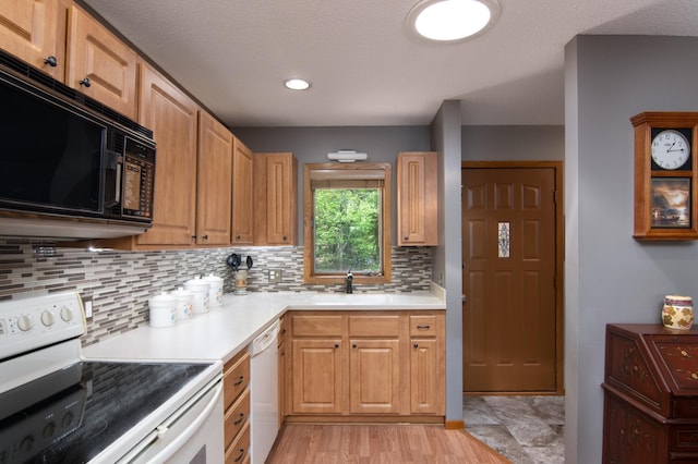 215 Park Dr Unit 4, Balsam Lake, WI 54810 - kitchen featuring white appliances, a sink, decorative backsplash, and light countertops