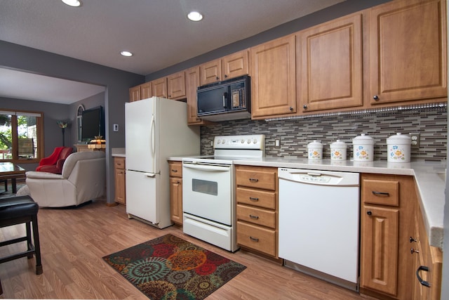 215 Park Dr Unit 4, Balsam Lake, WI 54810 - kitchen with white appliances, light wood-type flooring, tasteful backsplash, light countertops, and open floor plan