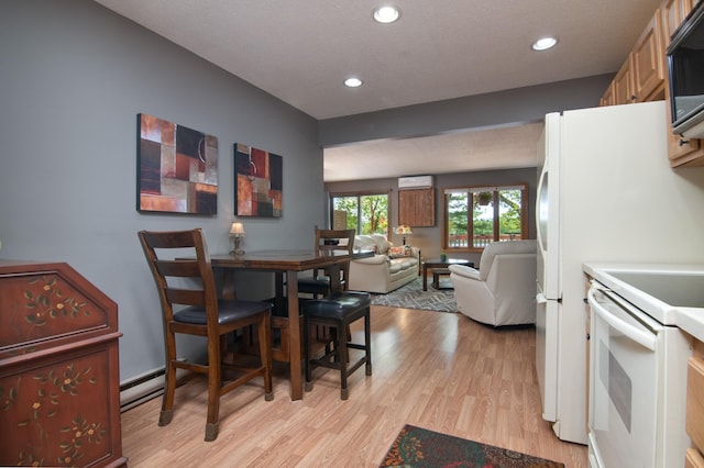 215 Park Dr Unit 4, Balsam Lake, WI 54810 - dining space featuring light wood-style flooring, recessed lighting, a wall mounted AC, and a baseboard heating unit