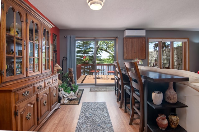 215 Park Dr Unit 4, Balsam Lake, WI 54810 - dining area featuring a wall mounted air conditioner, a textured ceiling, and light wood finished floors
