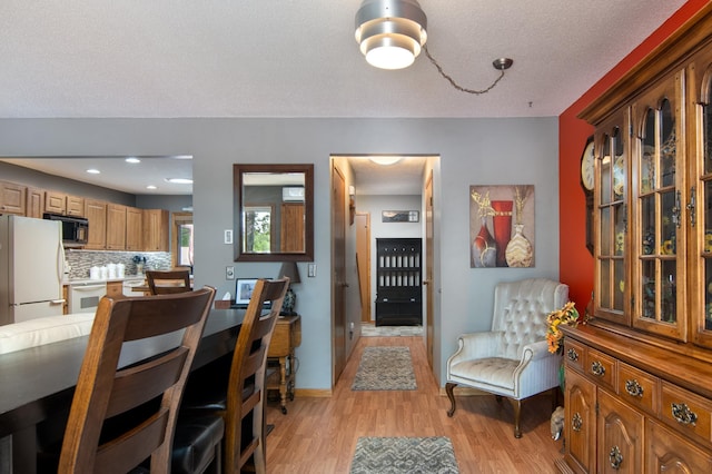 215 Park Dr Unit 4, Balsam Lake, WI 54810 - dining room with light wood finished floors, a textured ceiling, and baseboards