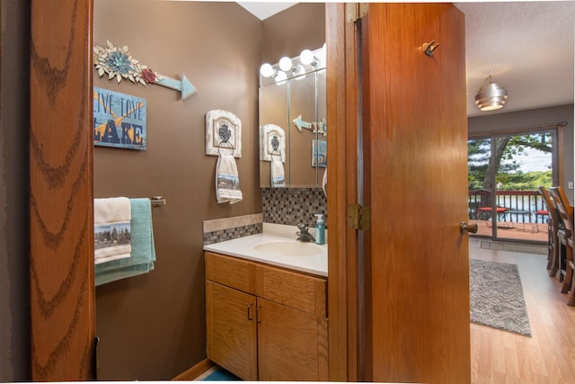 215 Park Dr Unit 4, Balsam Lake, WI 54810 - bathroom with wood finished floors, vanity, and decorative backsplash