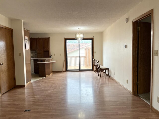 310 8th St, Windom, MN 56101 - living area featuring light wood finished floors, a chandelier, baseboards, and a textured ceiling